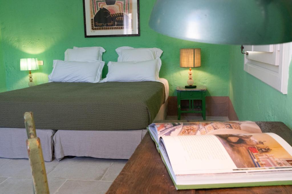 une chambre avec deux lits et une table avec un magazine dans l'établissement Masseria Torre Ruggeri, à Carpignano Salentino