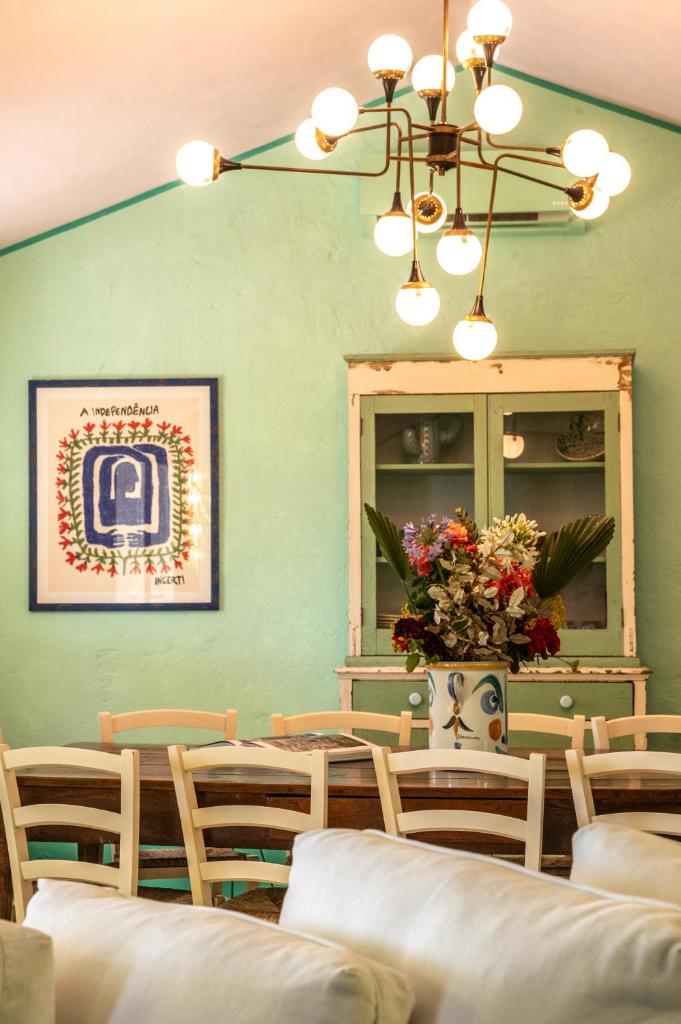 une salle à manger avec une table, des chaises et un lustre dans l'établissement Masseria Torre Ruggeri, à Carpignano Salentino