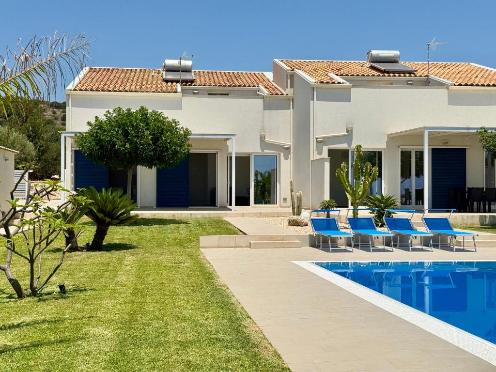 une villa avec une piscine et des chaises bleues dans l'établissement Villa Sema - Marina di Ragusa, à Marina di Ragusa 44 autres photos