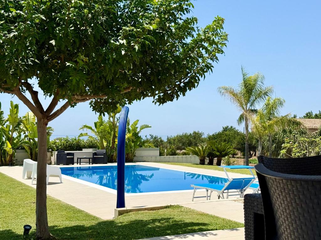 une piscine avec un arbre dans une cour dans l'établissement Villa Sema - Marina di Ragusa, à Marina di Ragusa