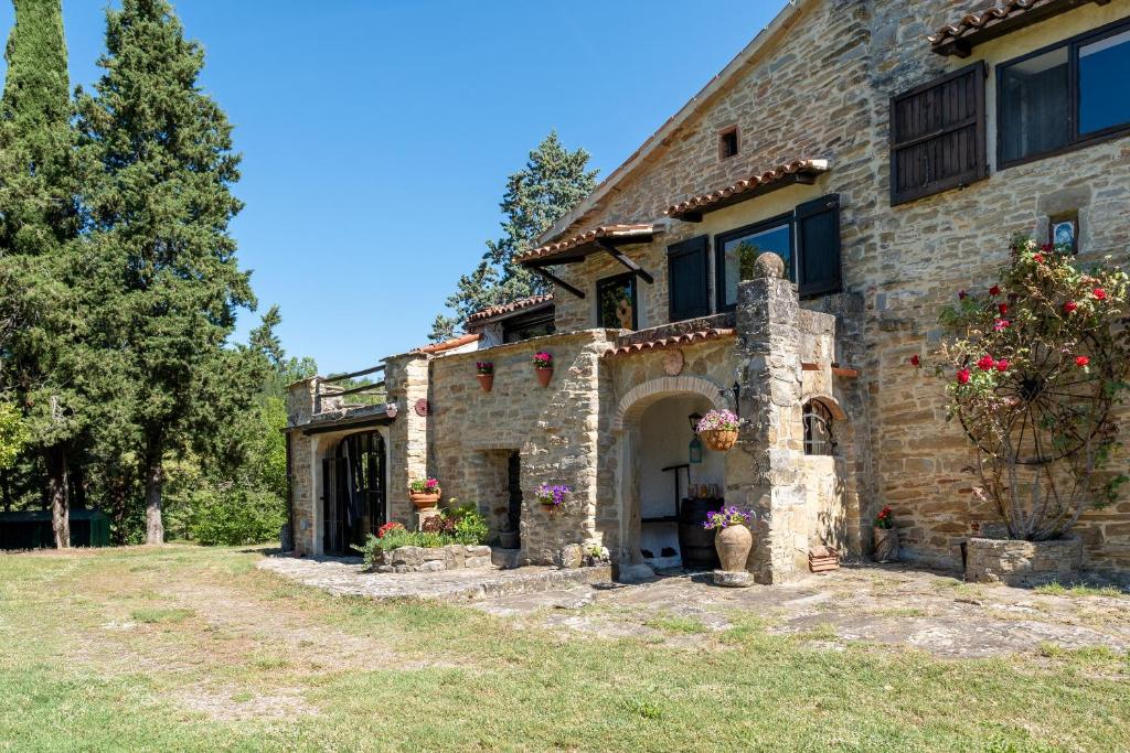 une maison en pierre avec des fleurs sur son côté dans l'établissement Il Rancho Grande, à Città di Castello
