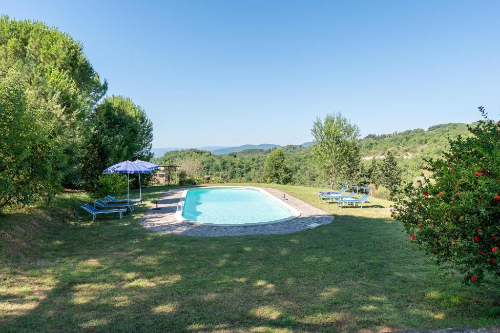 une piscine dans une cour avec un parasol dans l'établissement Il Rancho Grande, à Città di Castello