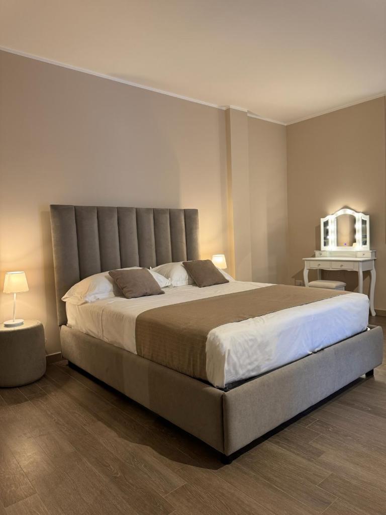 une chambre avec un grand lit dans une pièce dans l'établissement Samarè Rooms & Apartments, à Bisceglie
