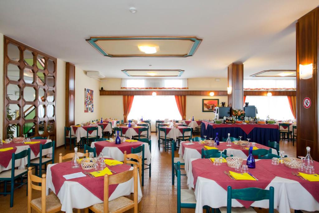 un restaurant avec tables et chaises et nappes rouges et bleues dans l'établissement Hotel Bettina, à Lido di Jesolo 34 autres photos
