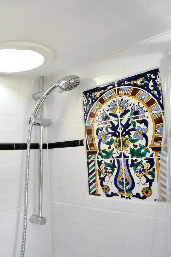 La salle de bains est pourvue d'une douche et d'un mur en mosaïque. dans l'établissement Peniche Alphonsia Maria, à Villeneuve-lès-Maguelone 37 autres photos