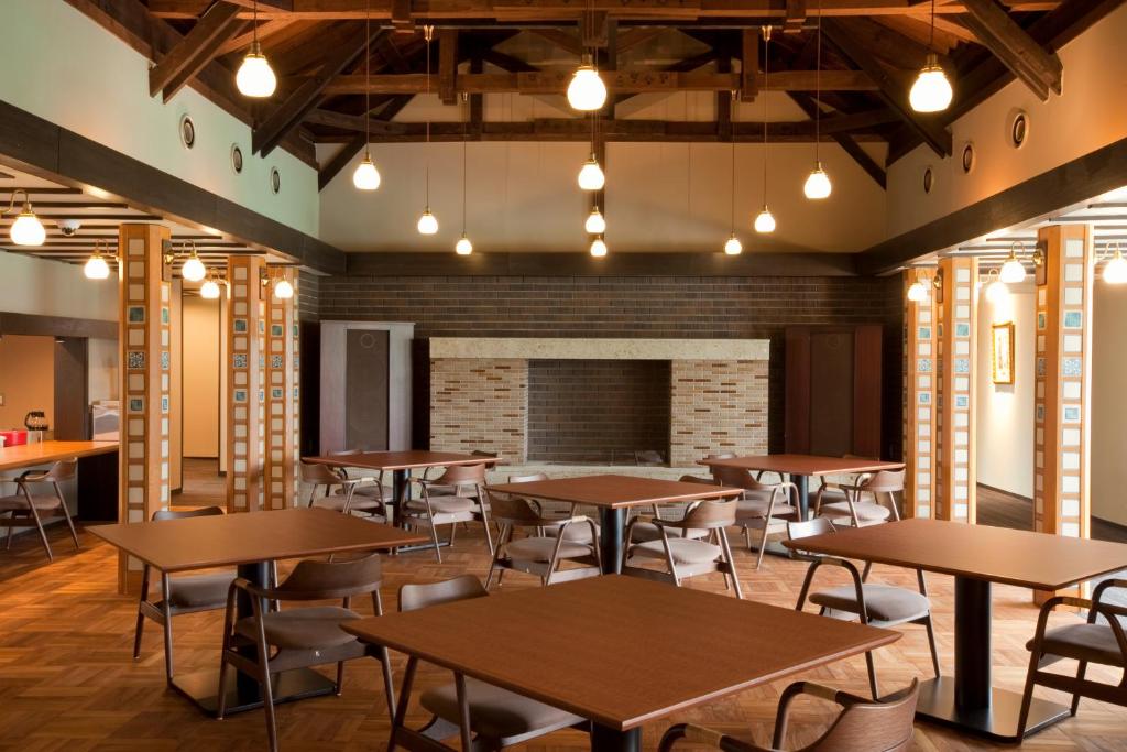 une salle à manger avec tables et chaises et une cheminée dans l'établissement AMANE resort GAHAMA, à Beppu