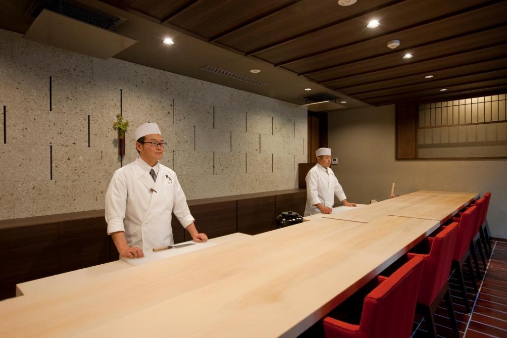 deux chefs assis sur une longue table avec des chaises rouges dans l'établissement AMANE resort GAHAMA, à Beppu 31 autres photos