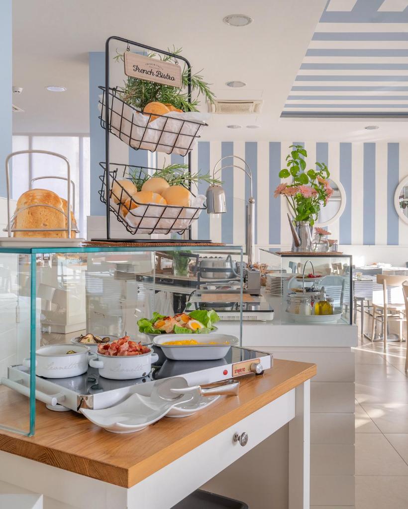 un buffet avec des assiettes de nourriture sur une table dans l'établissement Hotel Panorama, à Cattolica