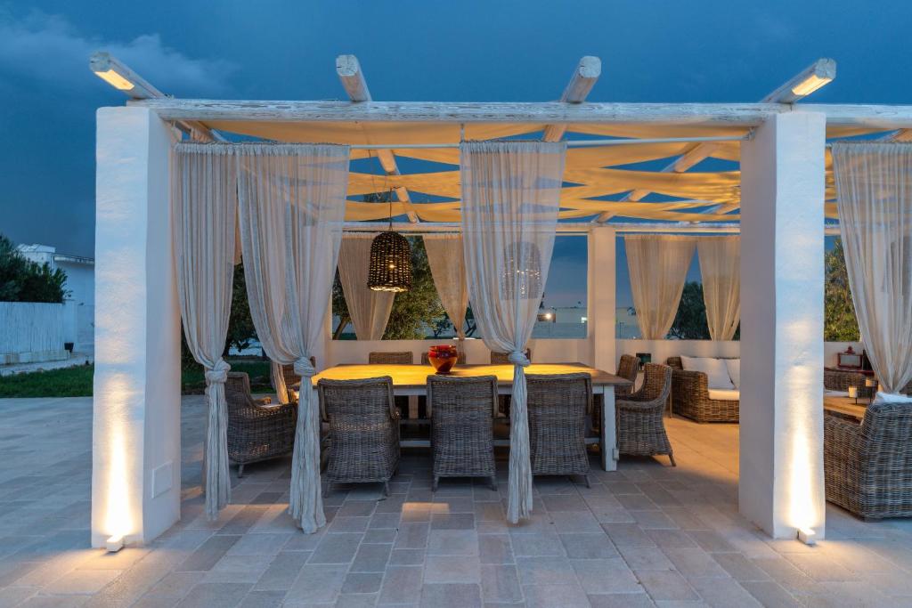 - un kiosque avec une table et des chaises sur la terrasse dans l'établissement Masseria Limonaia & Spa, à Fasano