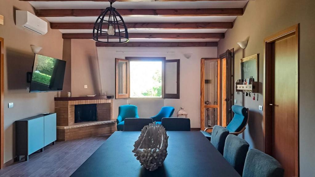 une salle à manger avec une table bleue et des chaises bleues dans l'établissement Villa Betta Cuntrariusa con piscina privata e jacuzzi a Scopello, à Castellammare del Golfo