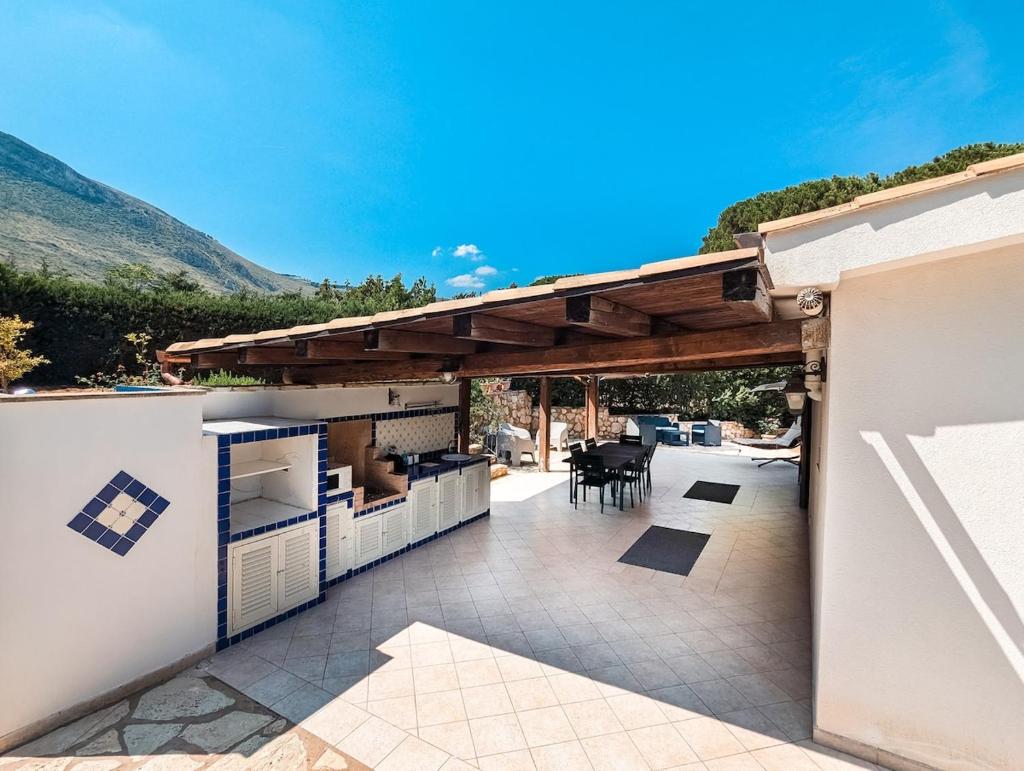 d'une terrasse avec un toit et une table et des chaises. dans l'établissement Villa Betta Cuntrariusa con piscina privata e jacuzzi a Scopello, à Castellammare del Golfo