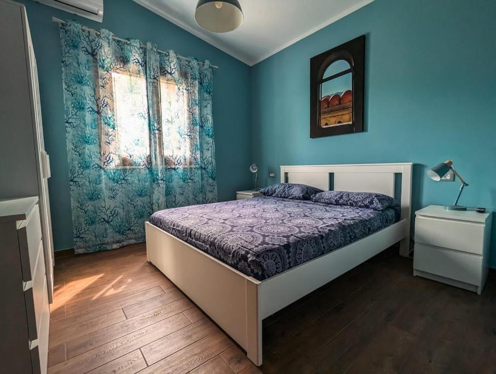 une chambre avec un lit et un mur bleu dans l'établissement Villa Betta Cuntrariusa con piscina privata e jacuzzi a Scopello, à Castellammare del Golfo 47 autres photos