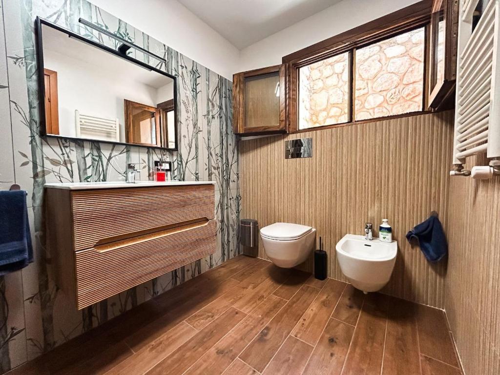 une salle de bain avec un lavabo, des toilettes et un miroir dans l'établissement Villa Betta Cuntrariusa con piscina privata e jacuzzi a Scopello, à Castellammare del Golfo