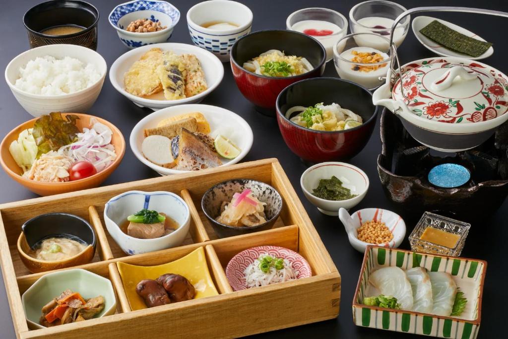 un groupe de bols de nourriture sur une table dans l'établissement Onyado Shikishima-kan, à Kotohira