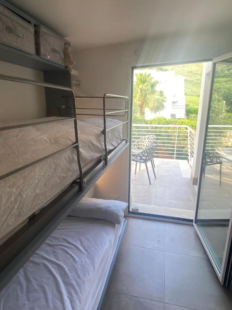 - une chambre avec des lits superposés et un balcon dans l'établissement Giardino degli Allori, Villa Manfredi with Pool, à Castellammare del Golfo