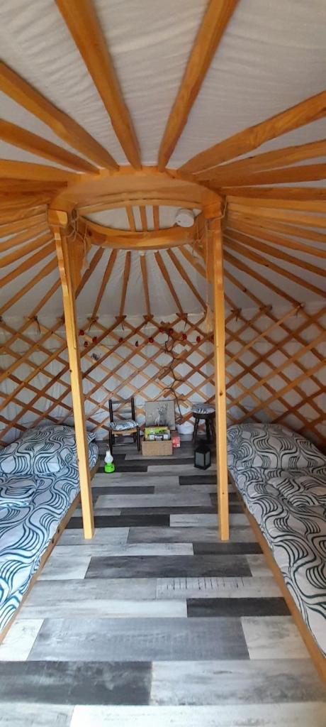 une vue intérieure d'une pièce mansardée en bois avec un toit dans l'établissement 2 Yourtes au naturel, à Druyes-les-Belles-Fontaines