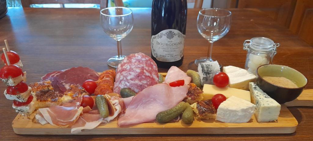 une assiette de différents types de fromages et des verres à vin dans l'établissement 2 Yourtes au naturel, à Druyes-les-Belles-Fontaines