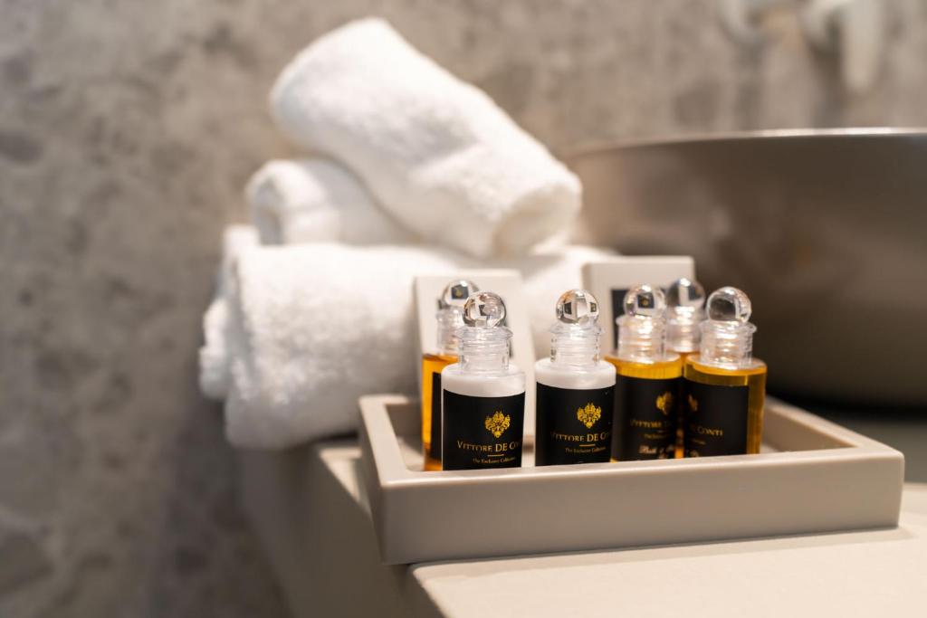 un groupe de bouteilles d'huiles essentielles assises sur un comptoir de salle de bains dans l'établissement Villa Verdeoro, à Montesilvano