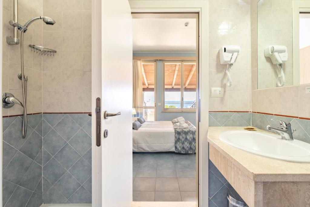une salle de bain avec un lavabo et une douche dans l'établissement Hotel La Caletta Village, à La Caletta