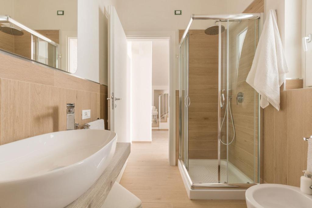 une salle de bain avec une baignoire blanche et une douche dans l'établissement Villa Adele by Perle di Puglia, à Maruggio