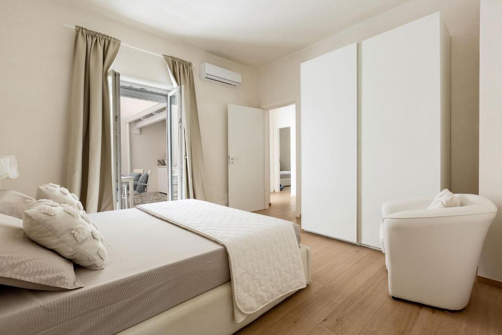 une chambre blanche avec un lit et un miroir dans l'établissement Villa Adele by Perle di Puglia, à Maruggio