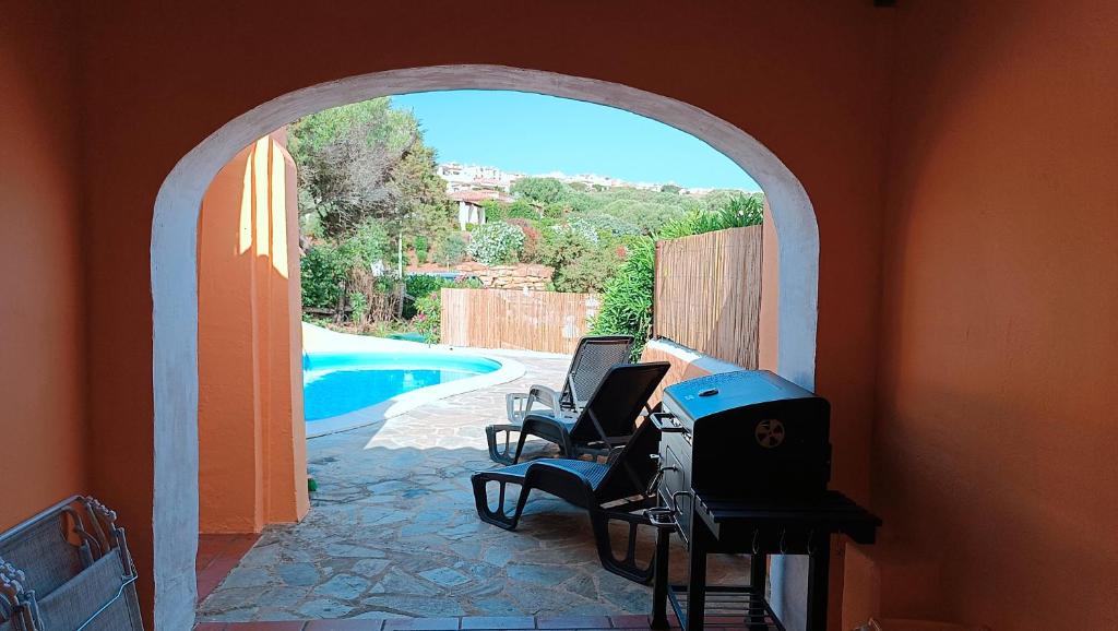 une pièce avec une arche avec des chaises et une piscine dans l'établissement Villa Verde splendida villa con piscina - Stintino Sardegna, à Cuile Pazzoni