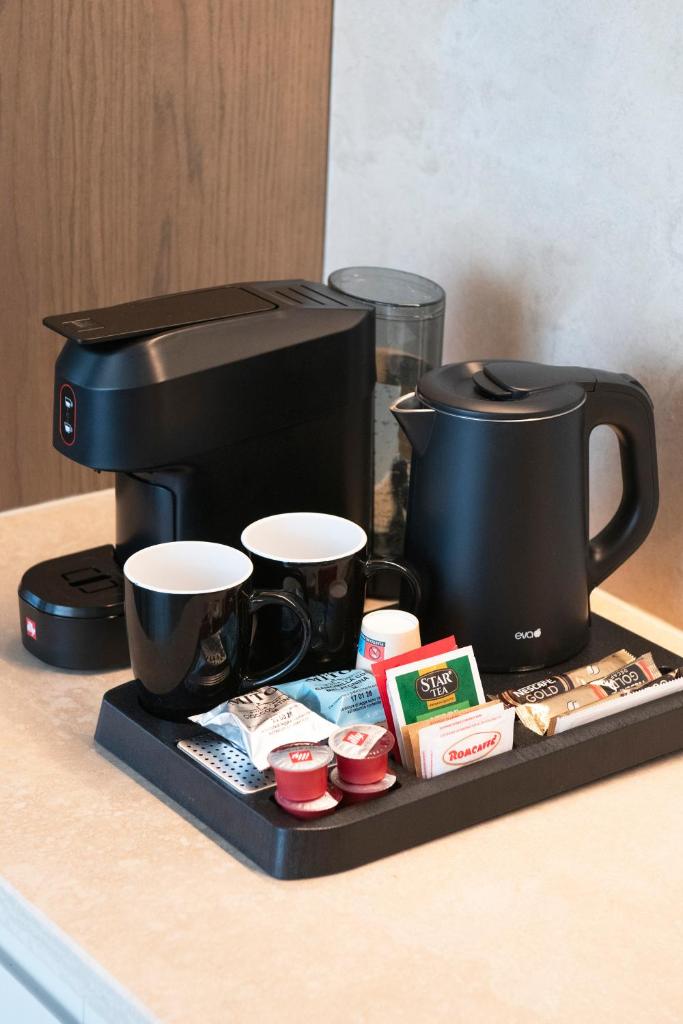 - une cafetière noire avec 2 tasses sur un plateau dans l'établissement International Hotel & Suite - In prima fila sul lungomare, à San Benedetto del Tronto