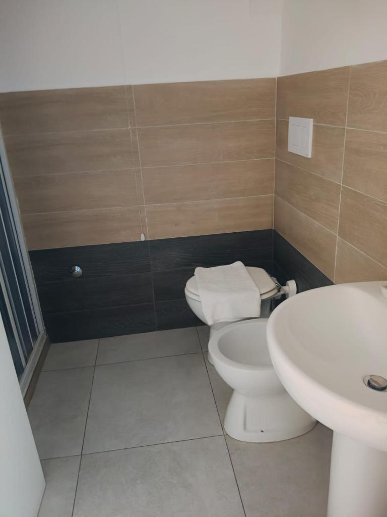 une salle de bain avec des toilettes blanches et un lavabo dans l'établissement Meson Feliz, à Terracine