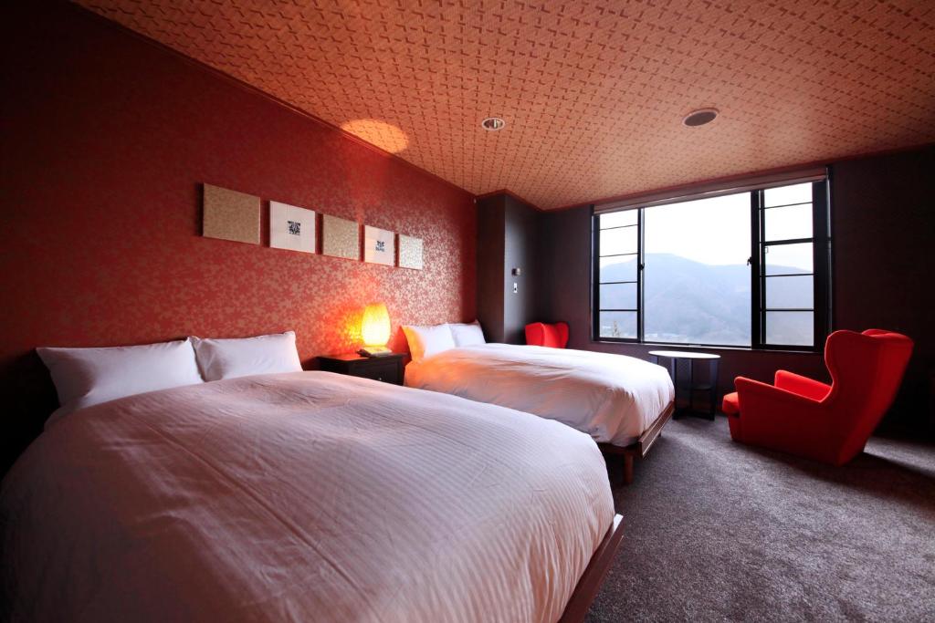une chambre avec deux lits et une chaise et une fenêtre dans l'établissement Bettei Koyoi - Adult Only, à Hakone