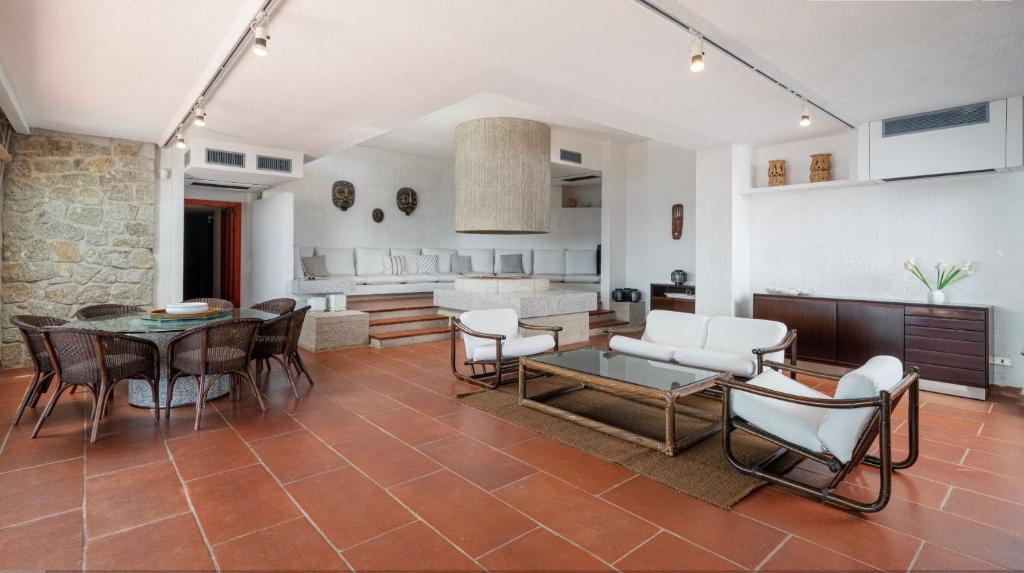 une cuisine et un salon avec une table et des chaises dans l'établissement Pedra - Seaside & pool villa in wild Mediterranean, à San Stèfano