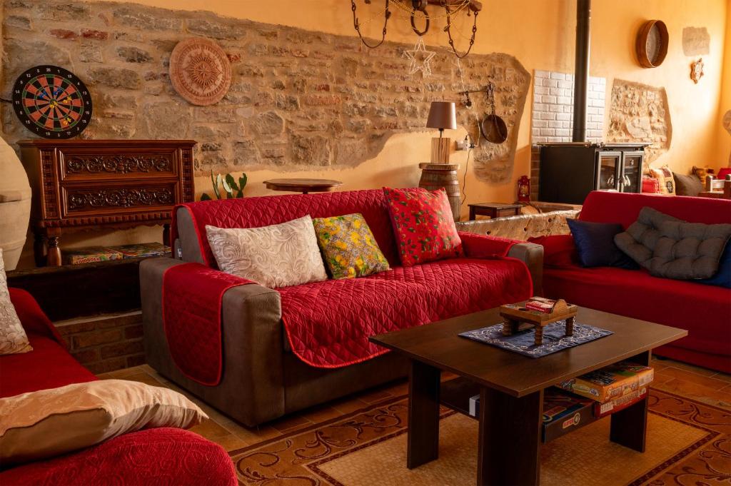 un salon avec un canapé rouge et une table dans l'établissement Appartamento Locazione Turistica L'Antica Sorgente Panicale, à Panicale