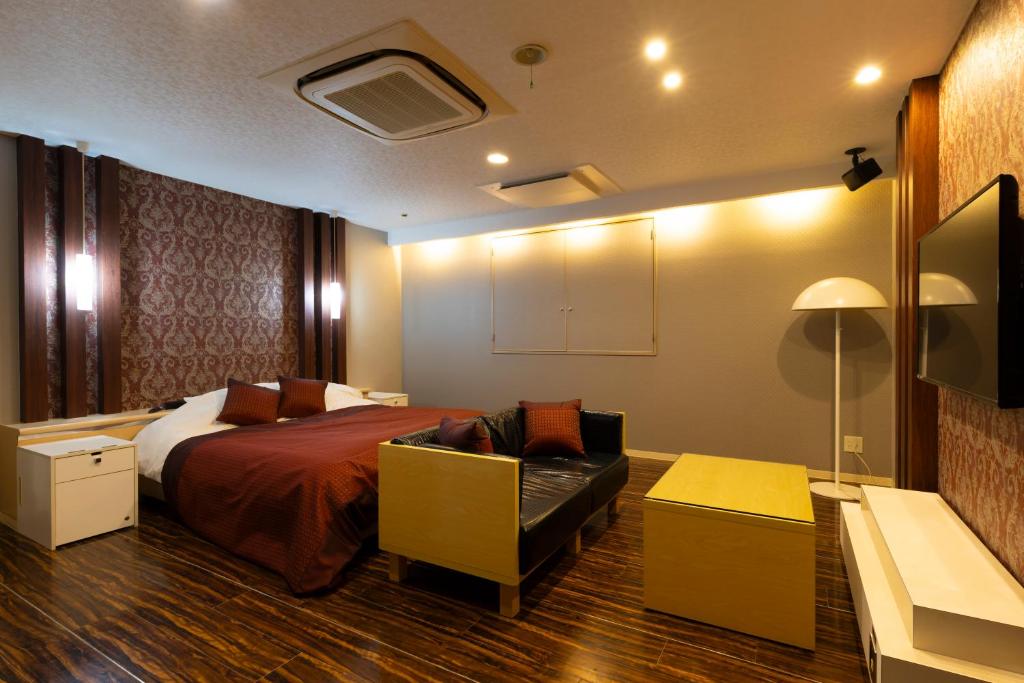 une chambre d'hôtel avec un lit et un canapé dans l'établissement パサディナホテル11 市原店, à Ichihara