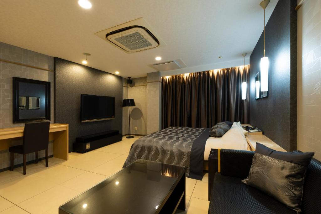 une chambre d'hôtel avec un lit et un bureau dans l'établissement パサディナホテル11 市原店, à Ichihara