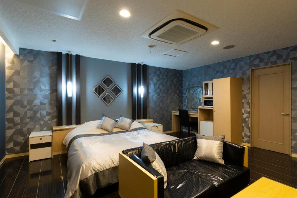 une chambre avec un lit et un canapé dans l'établissement パサディナホテル11 市原店, à Ichihara 4 autres photos