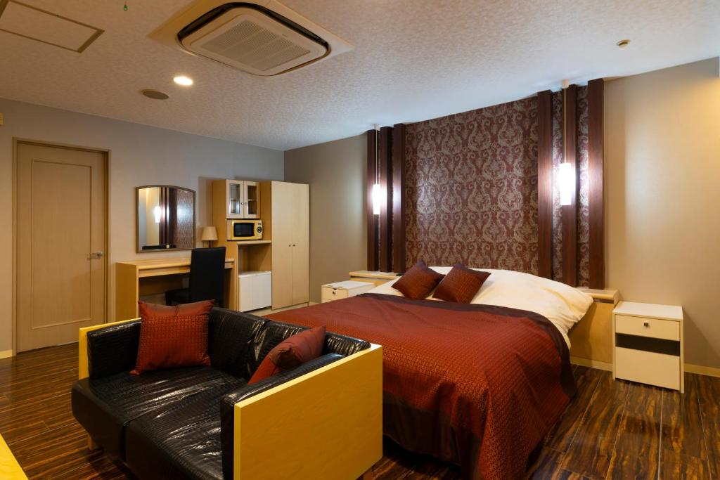 une chambre avec un lit et un canapé dans l'établissement パサディナホテル11 市原店, à Ichihara