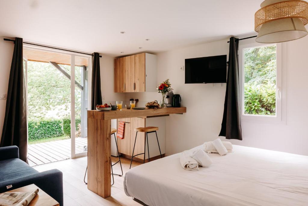 Cet appartement comprend une chambre avec un lit et une cuisine avec une fenêtre. dans l'établissement Slow Village Séveilles - Périgord, à Valades
