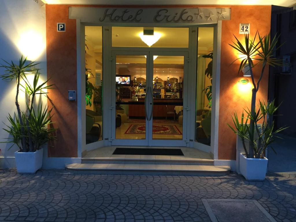 une porte menant à un magasin avec des plantes devant lui dans l'établissement Hotel Erika, à Caorle