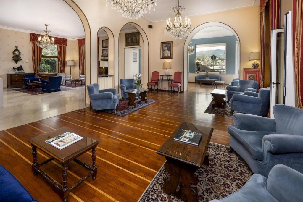 un salon avec des chaises bleues et une table dans l'établissement Best Western Regina Elena, à Santa Margherita Ligure