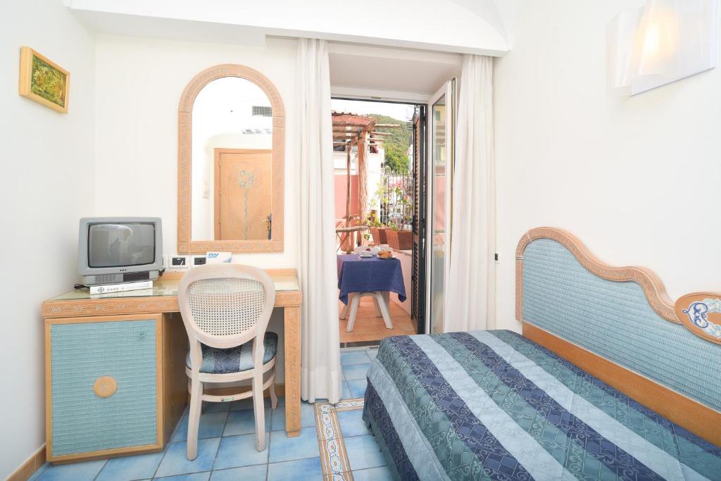 une chambre avec un lit et un bureau avec une télévision dans l'établissement Albergo Italia - Beach Hotel, à Ischia