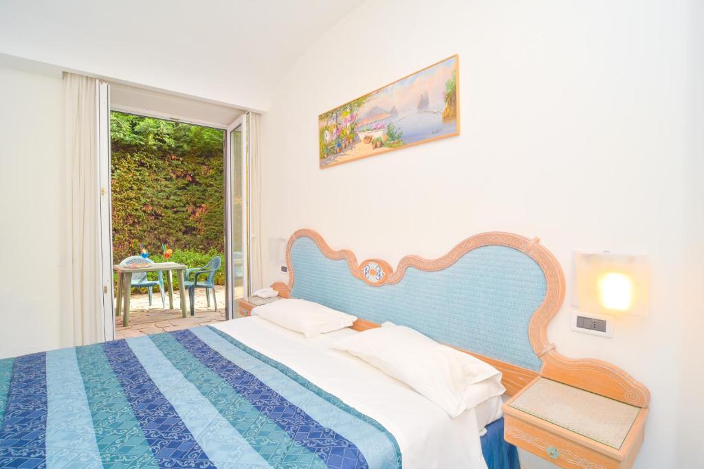une chambre avec un lit, une fenêtre et une table dans l'établissement Albergo Italia - Beach Hotel, à Ischia