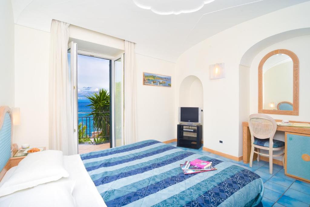 une chambre avec un lit et une vue sur l'océan dans l'établissement Albergo Italia - Beach Hotel, à Ischia