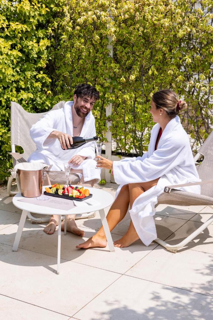 un homme et une femme assis à une table avec un gâteau dans l'établissement Open Hotel, à Rimini