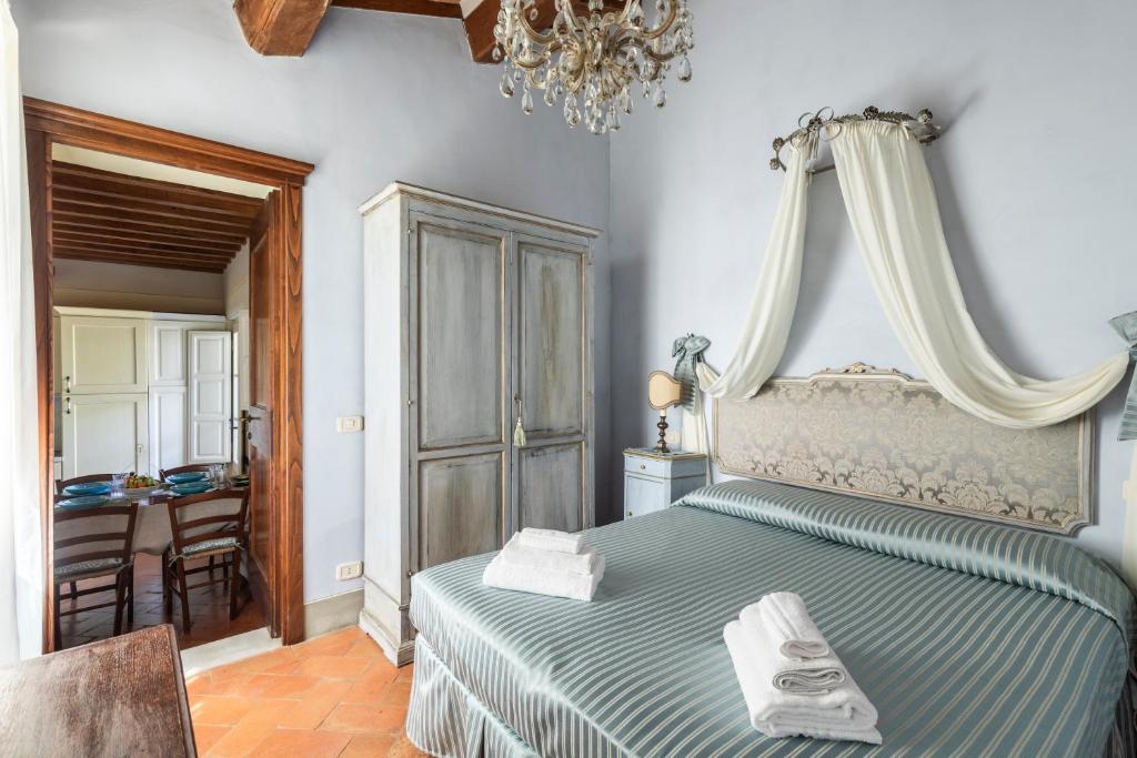une chambre avec un lit et un lustre dans l'établissement Il Borgo, à Arezzo