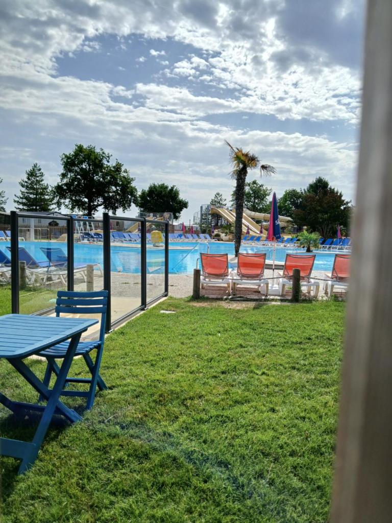 une table de pique-nique et des chaises devant un parc aquatique dans l'établissement sweet mobil-home, à Lège-Cap-Ferret