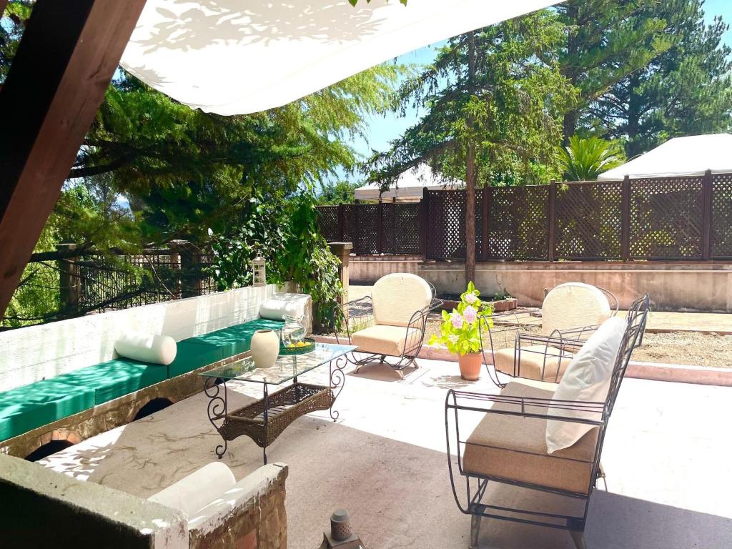 une terrasse avec des chaises, une table et une piscine dans l'établissement Villa in Cefalù with Pool and Forest Retreat, à Castelbuono