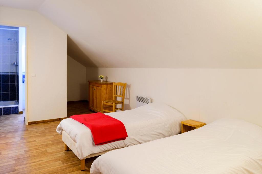 - une chambre avec 2 lits et une couverture rouge dans l'établissement Les Hauts de Valmeinier, à Valmeinier 21 autres photos