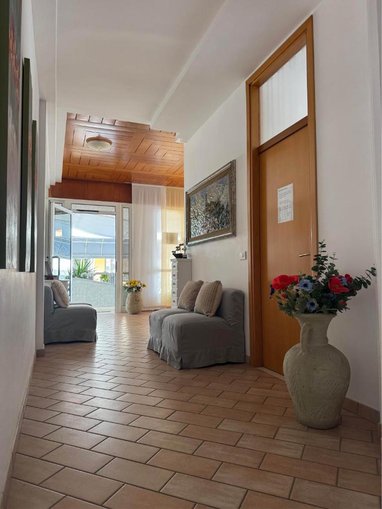 - un salon avec deux canapés et un vase avec des fleurs dans l'établissement Residence Moresco, à Lido di Jesolo