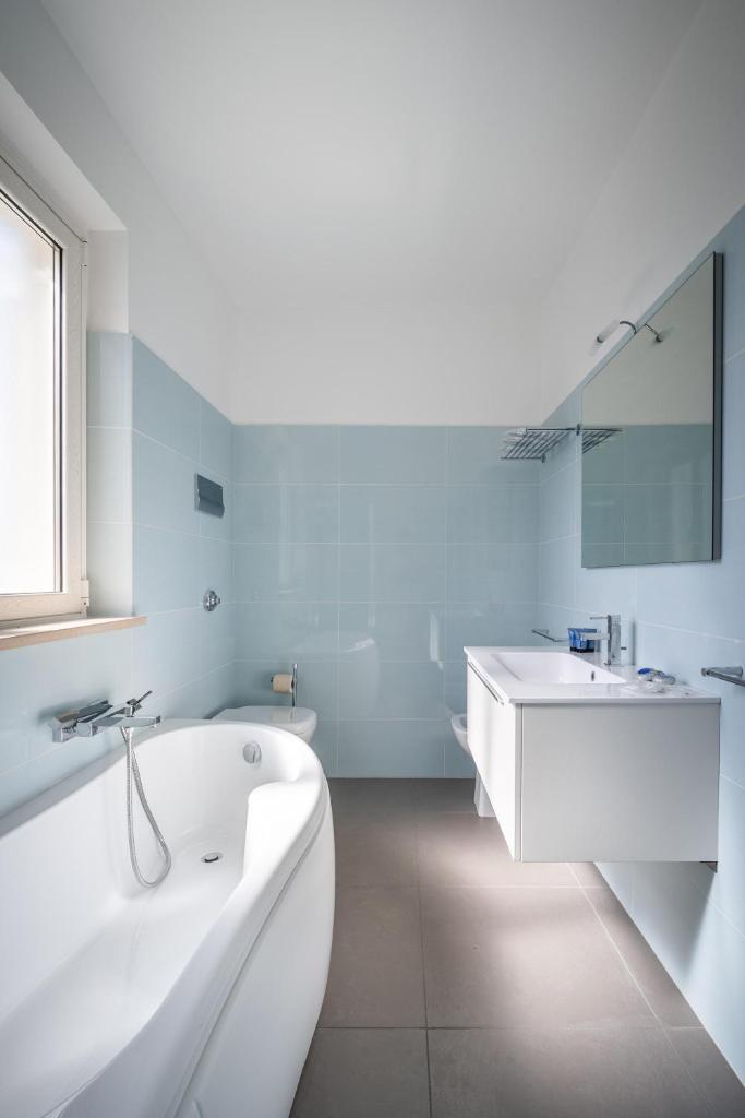 une salle de bain blanche avec une baignoire et un lavabo dans l'établissement Villa Stellata, à Naso