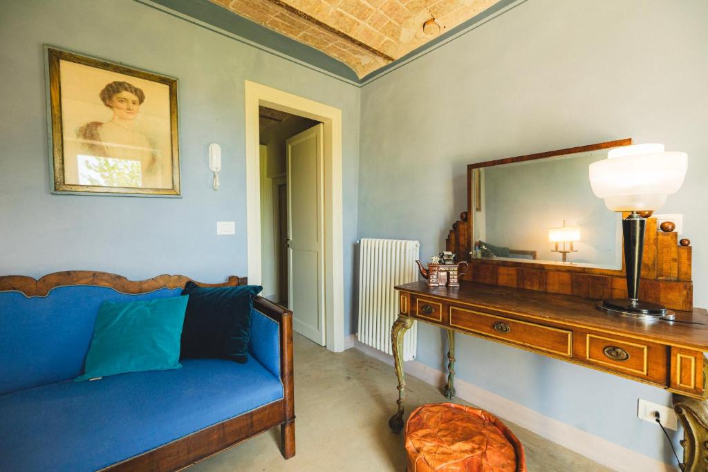 un salon avec un canapé bleu et un miroir dans l'établissement tHE Timeless Villa - Natural Bio Pool in Monferrato, à Castellino