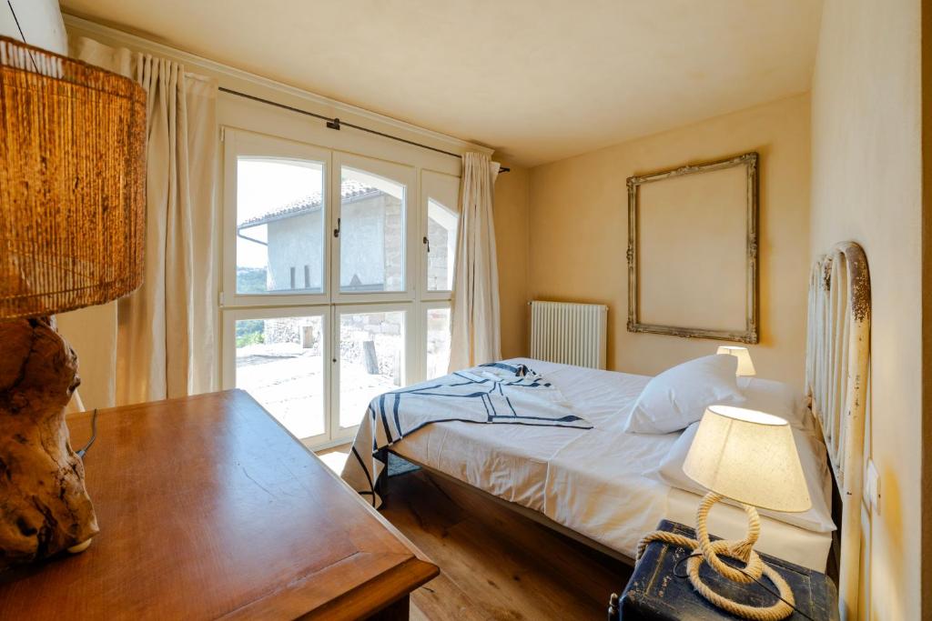 une chambre avec un lit, une table et une fenêtre dans l'établissement tHE Timeless Villa - Natural Bio Pool in Monferrato, à Castellino